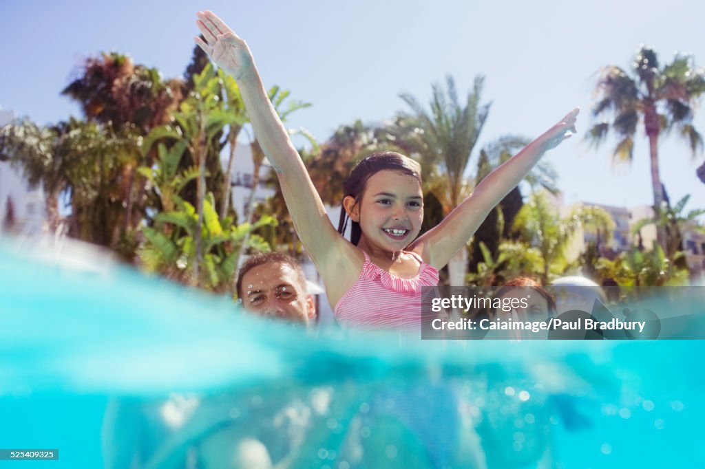 Padres con hija jugando en la piscina