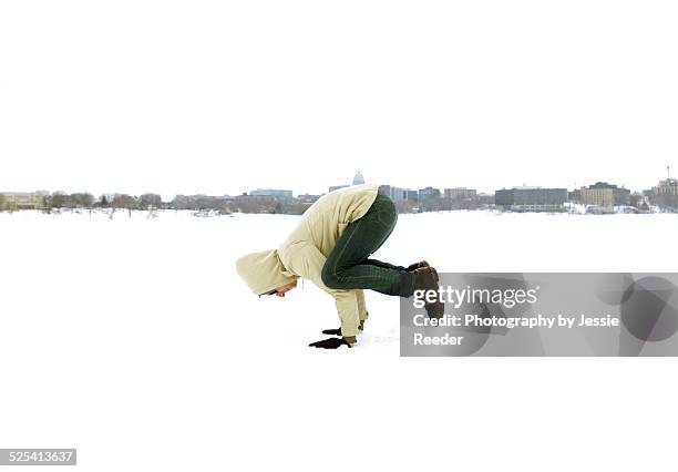 man doing yoga pose outside in snow - lake mendota stock pictures, royalty-free photos & images