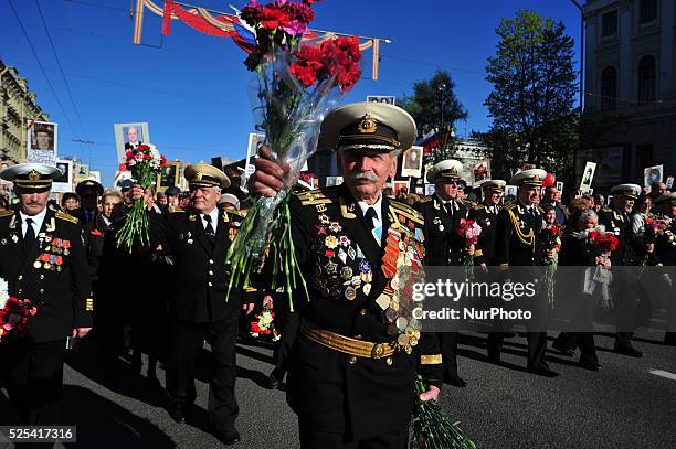 Veteran holds flowers as he marches to mark the 70th anniversary of Victory day in St. Petersburg,Russia, May 9, 2015.