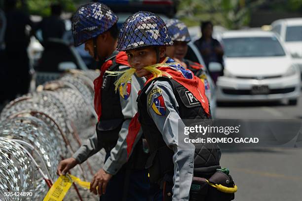 Myanmar police layout barbwire outside the US embassy before the arrival of supporters and monks belonging to the hardline Buddhist group Mabatha at...