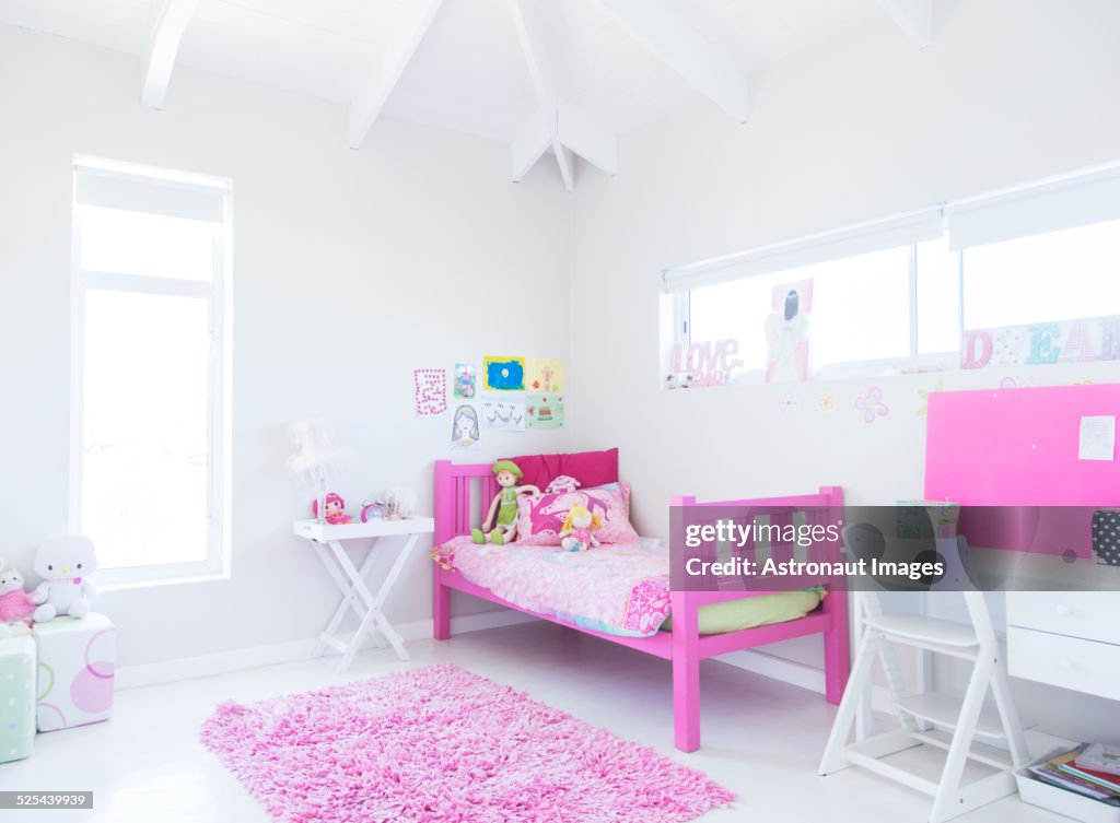 Girls bedroom with pink bed, rug and toys