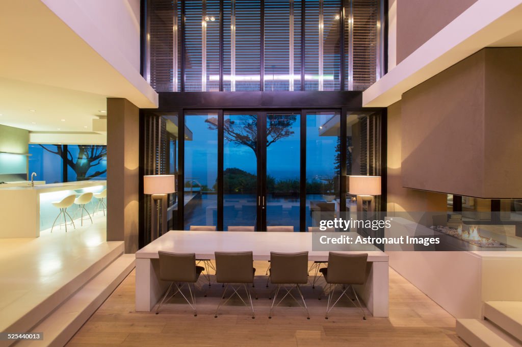 Modern dining room with fireplace and kitchen at night