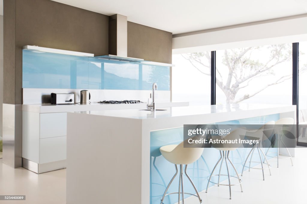 White and clean modern kitchen with stools at kitchen island