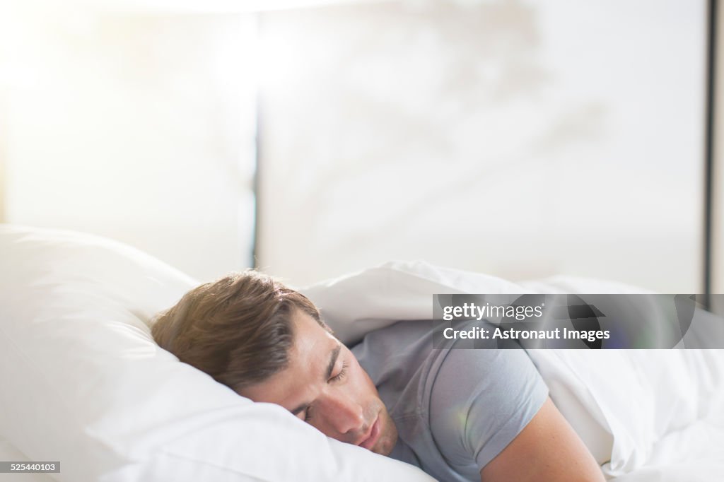 Young man sleeping in bed