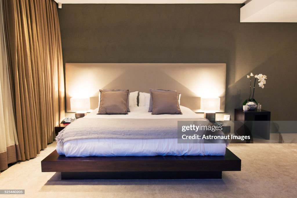 Modern bedroom with double bed illuminated at night