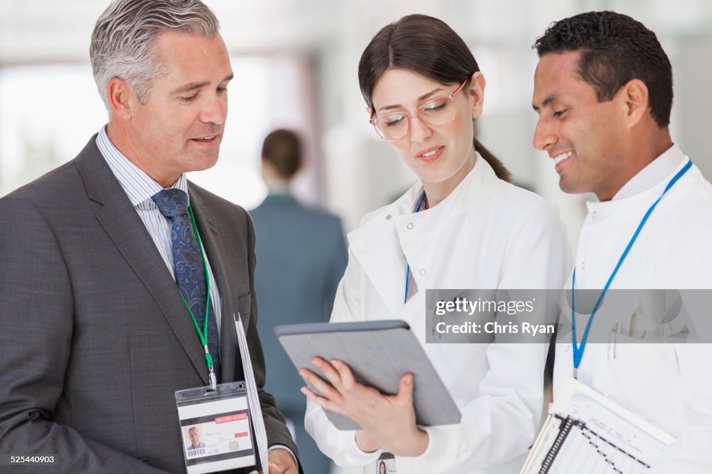 Scientists and businessman reading digital tablet