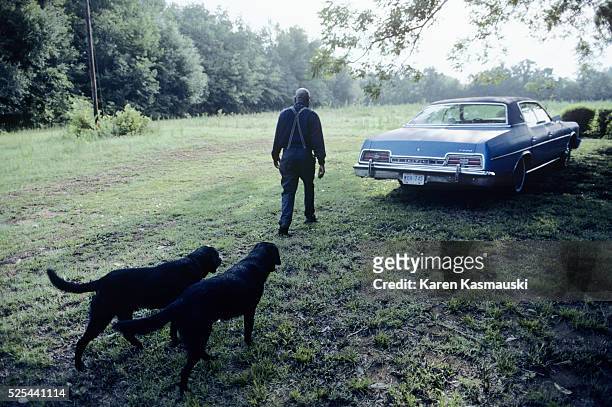 Reverend John Chaplin walks with his dogs on his farm in Frogemore, a multi-generation African American family typical of those in the Sea Islands...