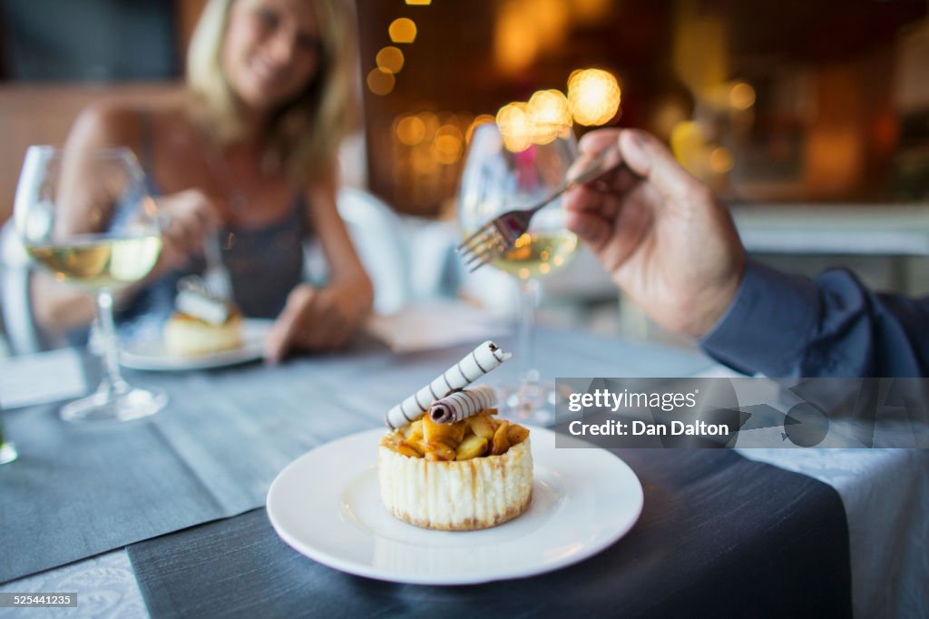 Couple eating dessert in fancy restaurant