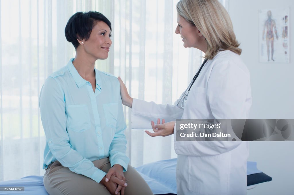 Smiling female doctor talking to patient in office