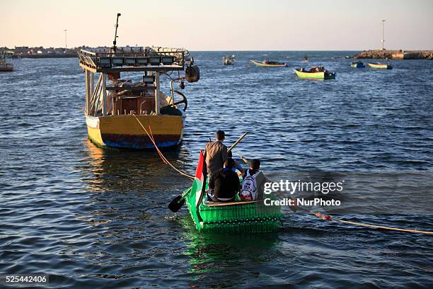 Young Palestinians on their boat made from remnants of empty plastic bottles inside the port of Gaza City on April 19, 2015