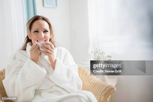 usa, new jersey, jersey city, woman wearing bathrobe drinking tea - bademantel stock-fotos und bilder