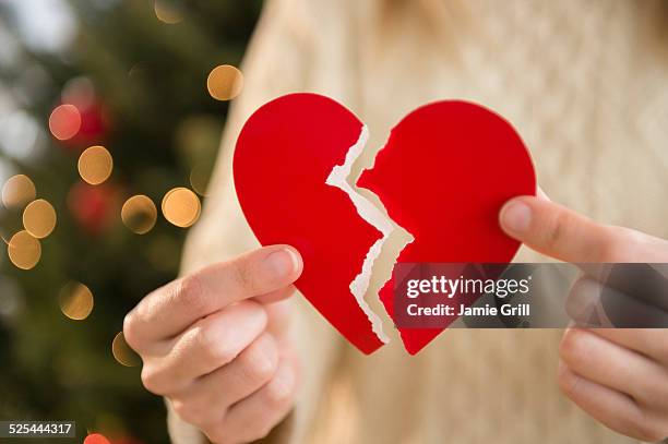 studio shot of female's hands holding broken heart - sad woman divorce stockfoto's en -beelden