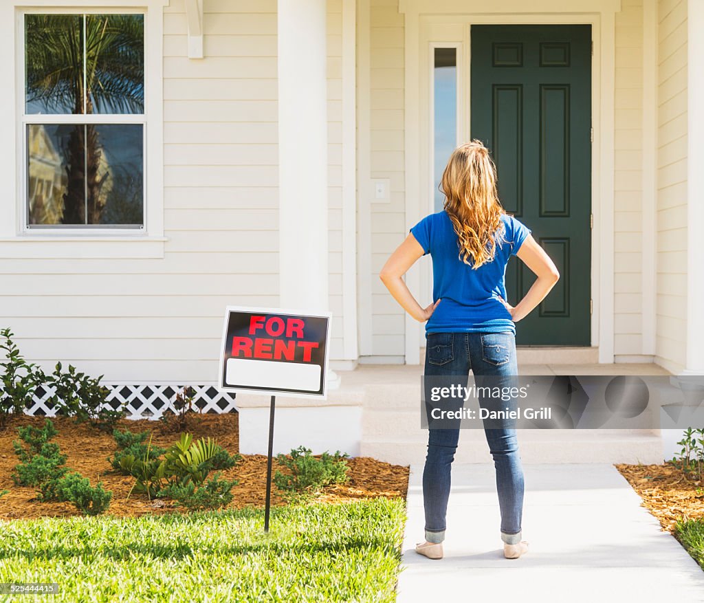 USA, Florida, Jupiter, Rear view of woman standing next to for rent sign