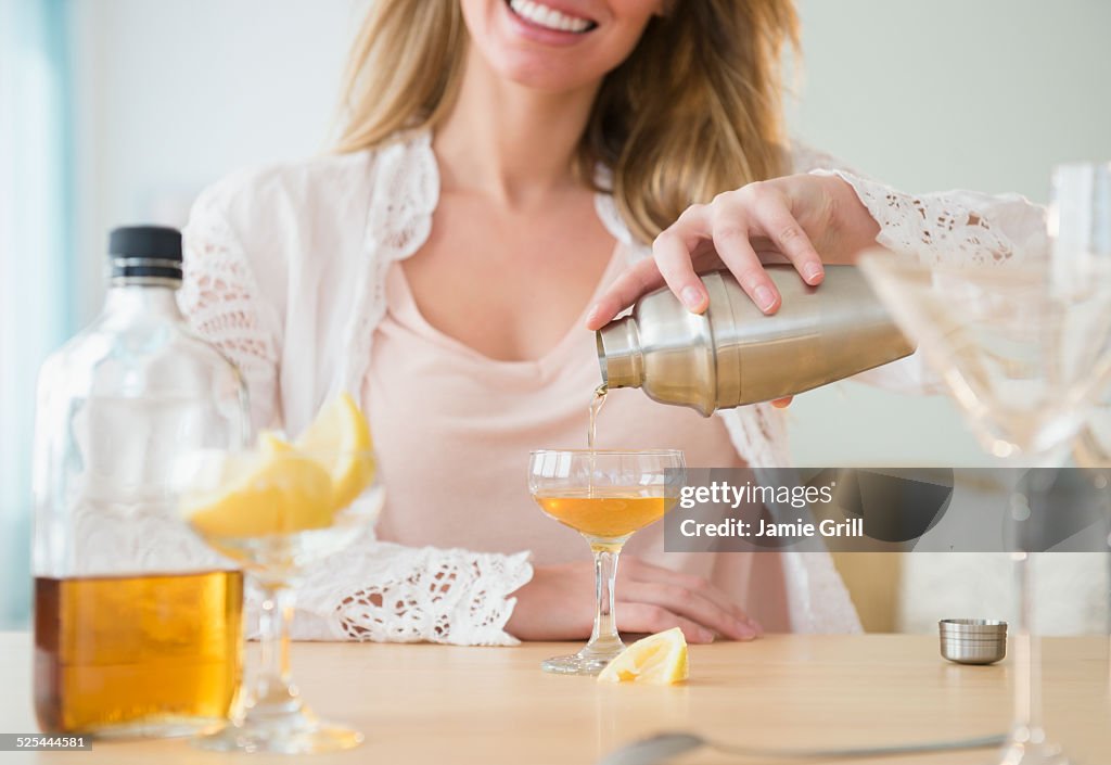 USA, New Jersey, Jersey City, Young woman pouring coctail