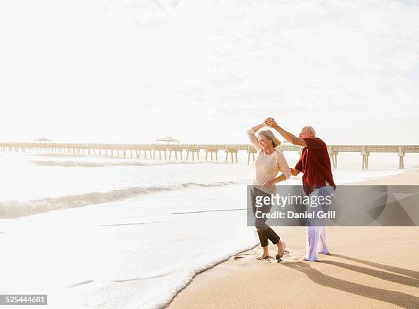 usa, florida, jupiter, senior couple dancing on beach - florida beach stock pictures, royalty-free photos & images