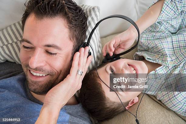 usa, new jersey, jersey city, father listening to music with son (8-9) - child listening differential focus stock pictures, royalty-free photos & images