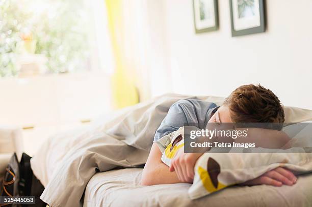 usa, new jersey, jersey city, teenage boy (16-17) sleeping in bed - boy asleep in bed stock pictures, royalty-free photos & images