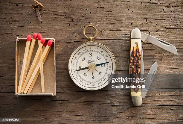 studio shot of matchsticks, compass and knife on wooden board - survival stock pictures, royalty-free photos & images