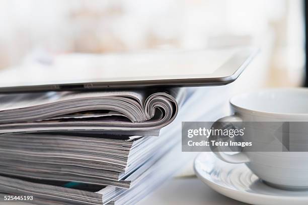 usa, new jersey, jersey city, close up of coffee cup and digital tablet on top of magazine stack - magazine stack stock pictures, royalty-free photos & images