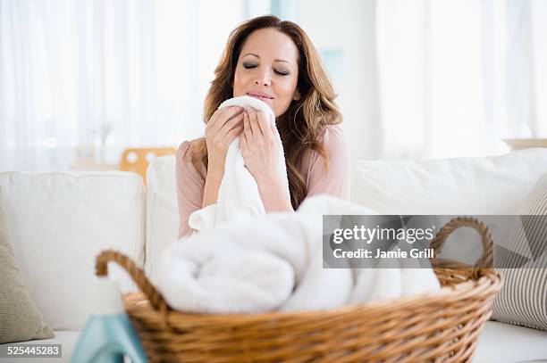 usa, new jersey, jersey city, woman smelling washed laundry - towel stock pictures, royalty-free photos & images