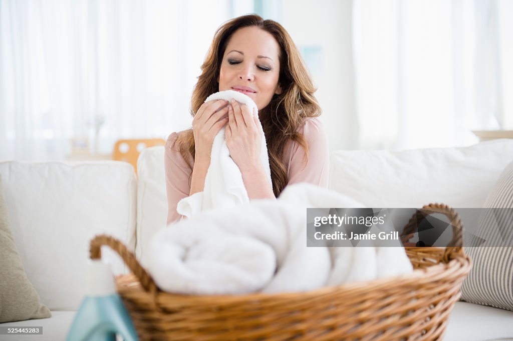 USA, New Jersey, Jersey City, Woman smelling washed laundry