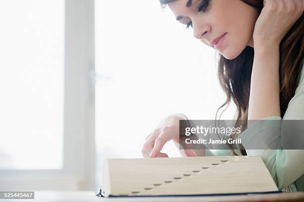 usa, new jersey, jersey city, young woman reading dictionary - woordenboek stockfoto's en -beelden