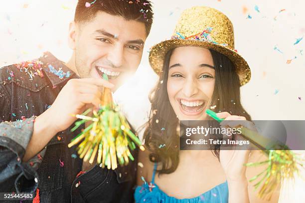 usa, new jersey, jersey city, young couple celebrating new year's eve - party blower stock-fotos und bilder