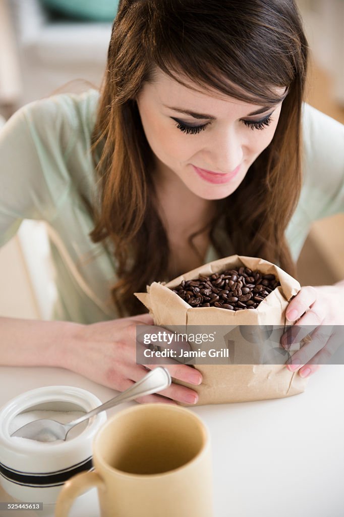 USA, New Jersey, Jersey City, Young woman smelling coffee beans