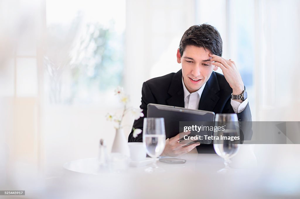 USA, New Jersey, Jersey City, Portrait of business man using digital tablet in restaurant