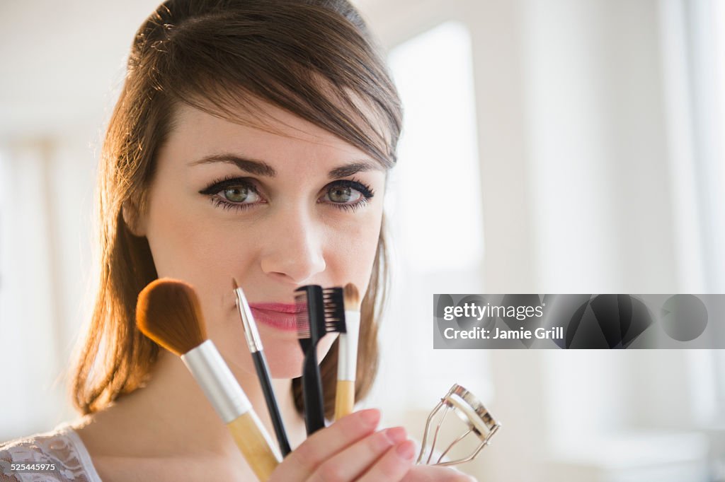 USA, New Jersey, Jersey City, Young woman holding make-up accessories