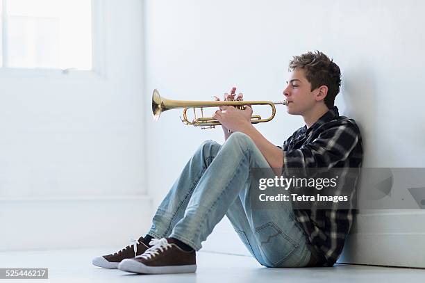 usa, new jersey, jersey city, teenage boy (16-17) playing trumpet in hallway - trumpet fotografías e imágenes de stock