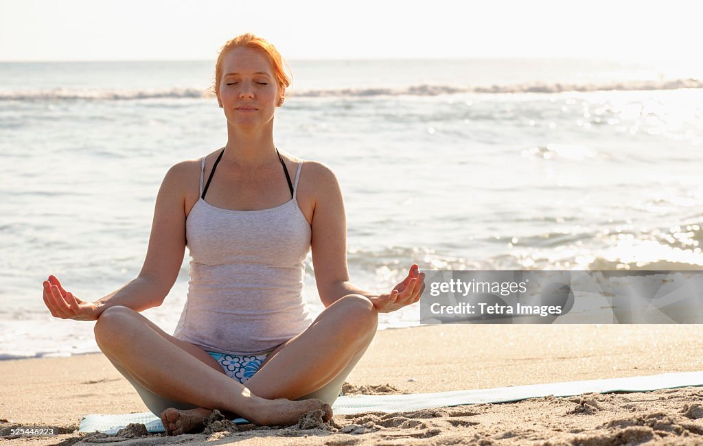 USA, Florida, Palm Beach, Woman practicing yoga on beach