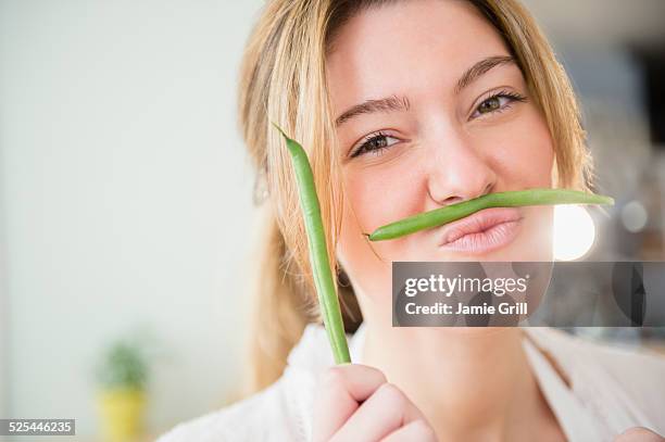 usa, new jersey, jersey city, portrait of blond woman holding green beans - haricot vert photos et images de collection