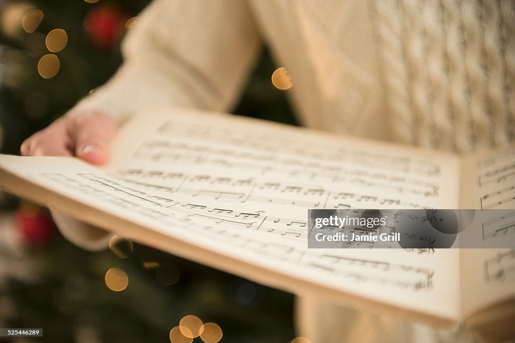 Studio Shot of woman holding sheet music at christmas