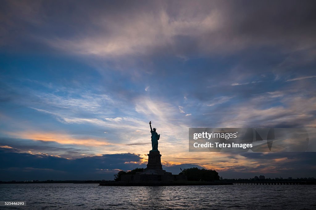 USA, New York, New York City, Silhouette of Statue of Liberty at sunset