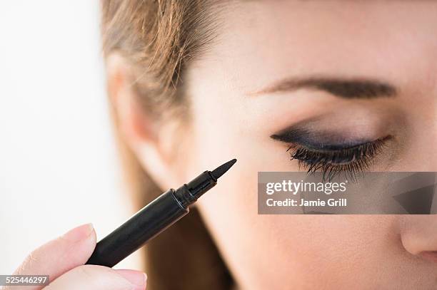 usa, new jersey, jersey city, young woman applying eyeliner - kajalschminke stock-fotos und bilder