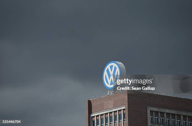 The logo of German automaker Volkswagen AG stands on an administrative building at the Volkswagen factory as a dark cloud passes behind on the day of...