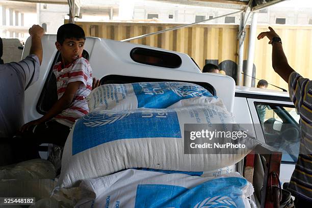 Palestinians receive their monthly food aid at a United Nations distribution center in the Rafah refugee camp, southern Gaza Strip on July 31, 2014....