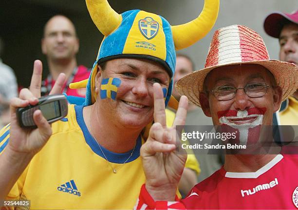 Fussball: Euro 2004 in Portugal, Vorrunde / Gruppe C / Spiel 22, Porto; Daenemark - Schweden ; Fans SWE und DEN zeigen den Spielstand an. 22.06.04.