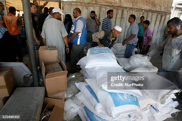 Palestinians receive their monthly food aid at a United Nations distribution center in the Rafah refugee camp, southern Gaza Strip on July 31, 2014....