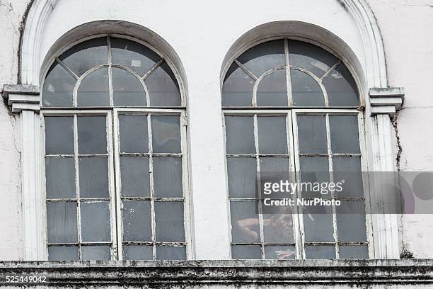 Manila, Philippines - A man peeks outside the window as he waits for Pope Francis to arrive at the Manila Cathedral for his mass on Friday, January...