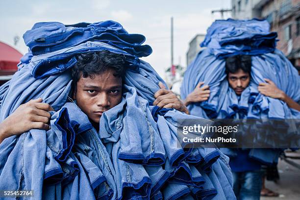 Two boys were carrying ready made jeans for as the eid is knocking at the door for the bengali muslims, Dhaka July12, 2015