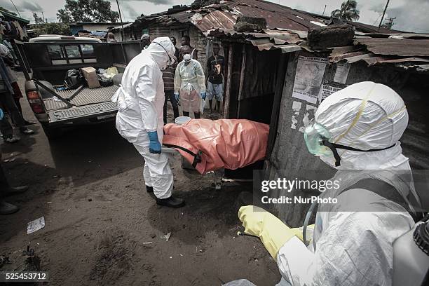 Garmai Sumo with the Liberian red cross supervises a burial team as they pull out the body of 40-year-old Mary Nyanforh, in Monrovia, Liberia, on...