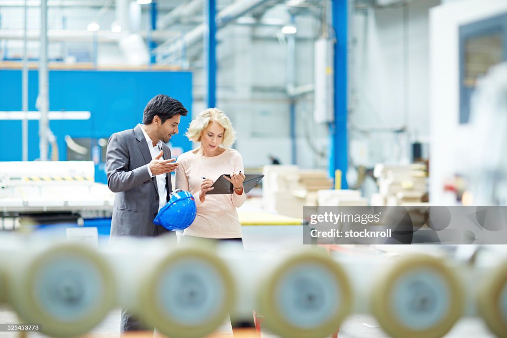 Businessman reporting production details to senior manager