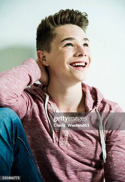 portrait of smiling teenager leaning against wall - portrait lachen imagens e fotografias de stock