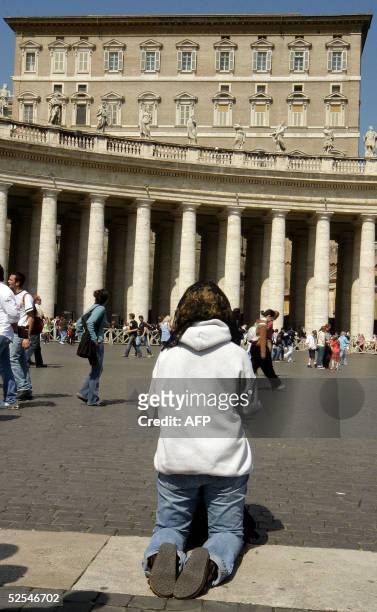 Pilgrim kneels in prayer in St Peter's square at Vatican 1 April 2005. Pope John Paul II received the last rites Thursday evening after suffering a...