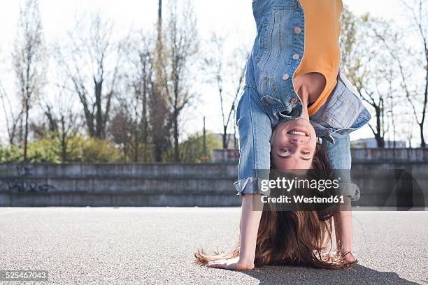 young woman doing a handstand - hacer el pino fotografías e imágenes de stock