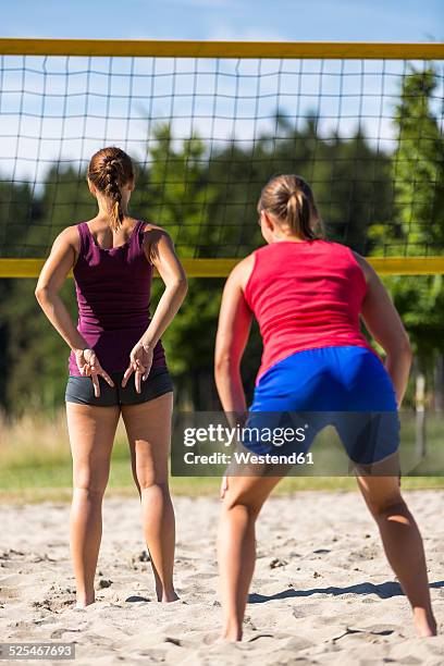 two young women playing beach volleyball - volleyball handzeichen stock-fotos und bilder