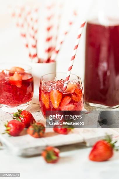 glass of iced red fruit tea with strawberries and crushed ice - ice tea stockfoto's en -beelden