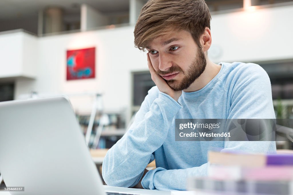 Student using laptop in a university library